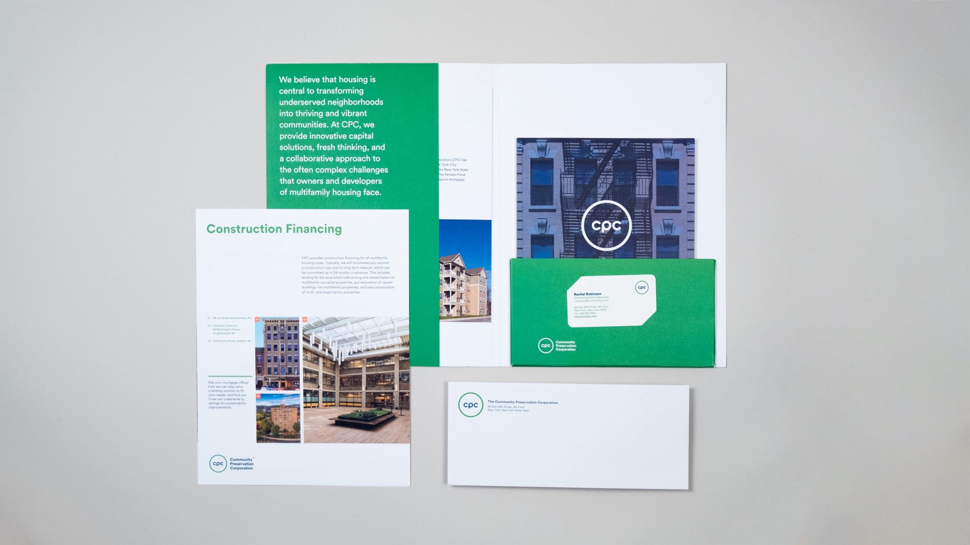 Full suite of brand materials laid out including a custom folder, capabilities brochure, one sheet, business envelope, and business card