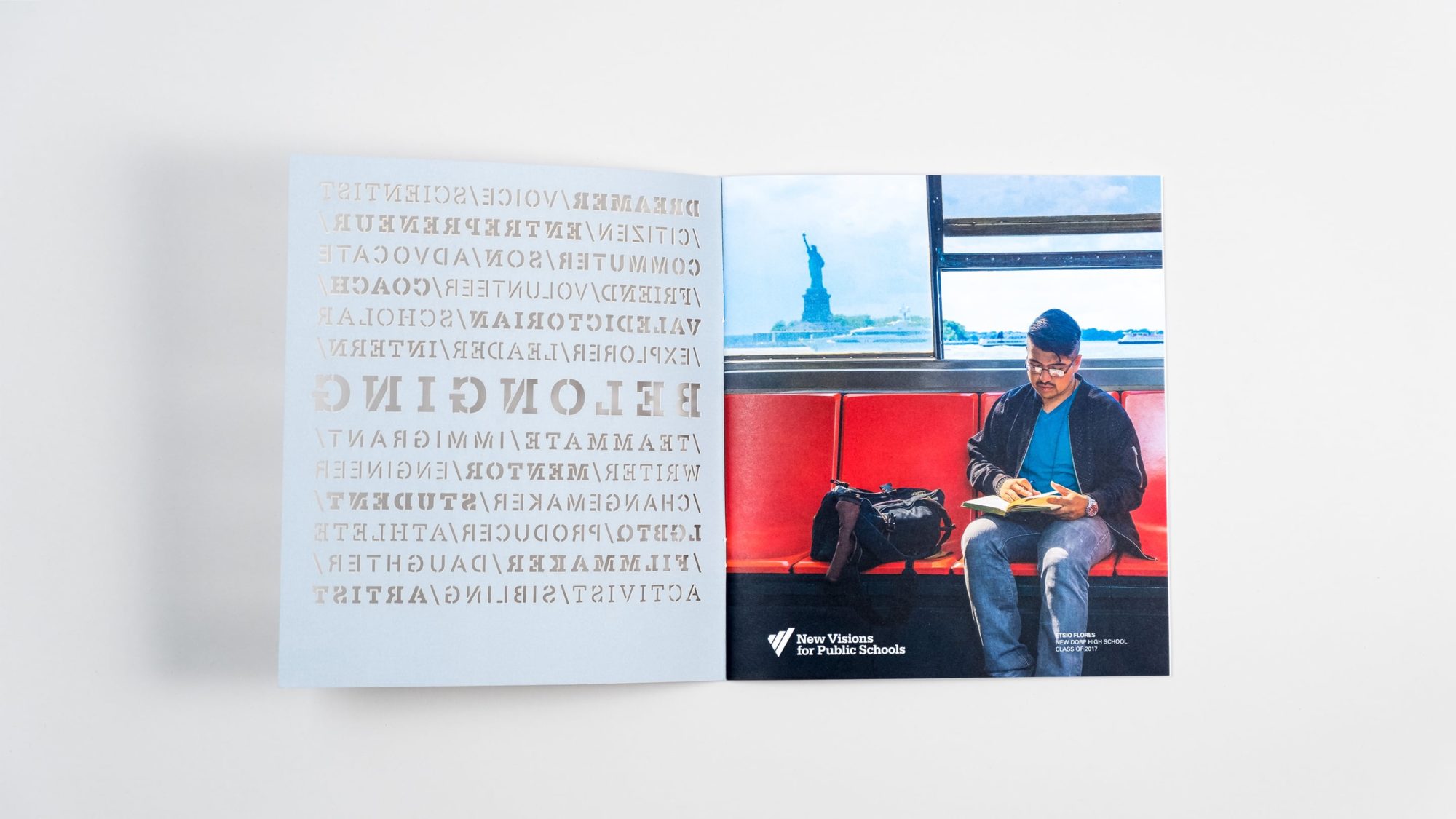 Inside front cover and opening page of annual report revealing photograph of New Visions student reading a book on the subway